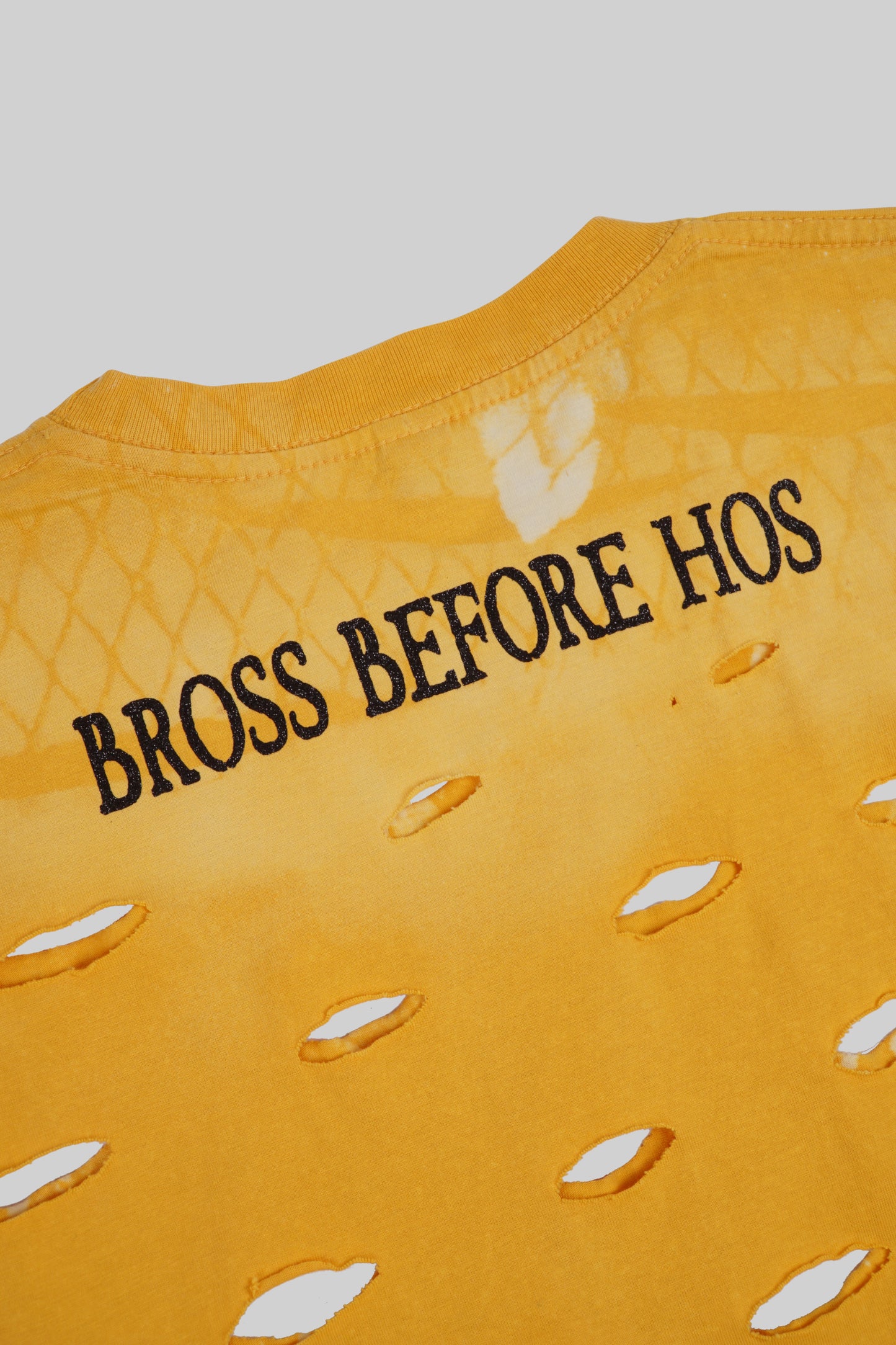 Black T-shirt with artistic hole designs by Bross Before Hos Boutique, casual style and unique distressed details.