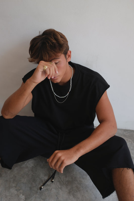 Black BROSS BEFORE HOS BOUTIQUE muscle top displayed on a hanger, highlighting its sleeveless design and casual style.